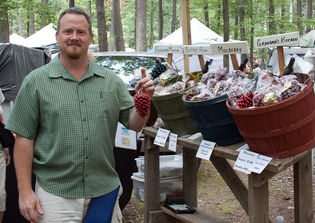 Gary Monk stands with one of his bees’ wax window ornaments. His stand sold ornaments that released fragrance as heat melted the wax on the pine cone away.