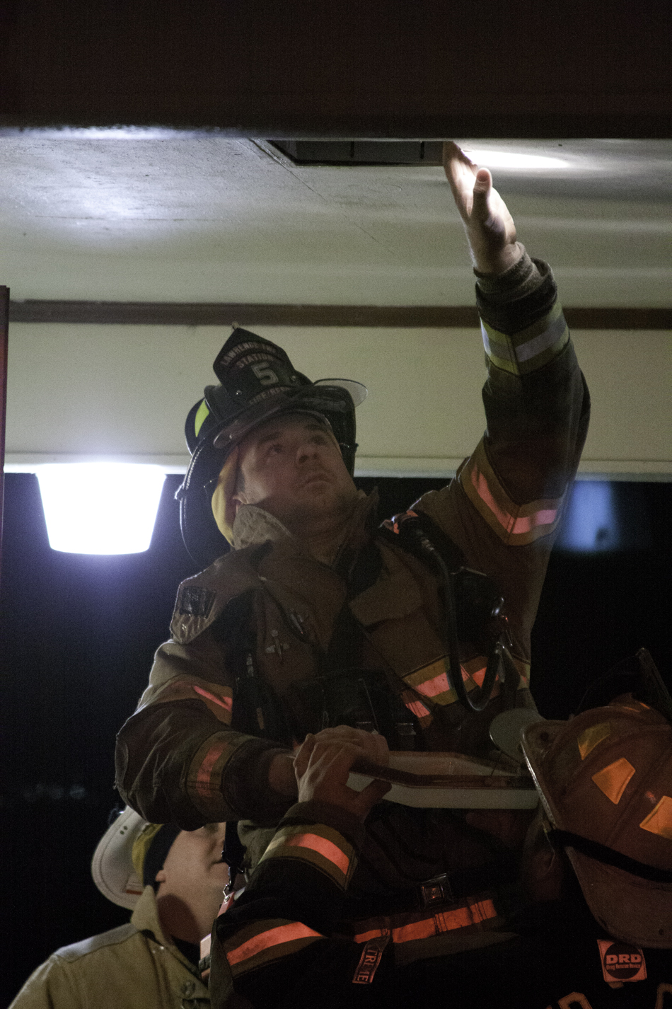 A firefighter pulls out one of the lights to get a closer look at the reported smoke smell.