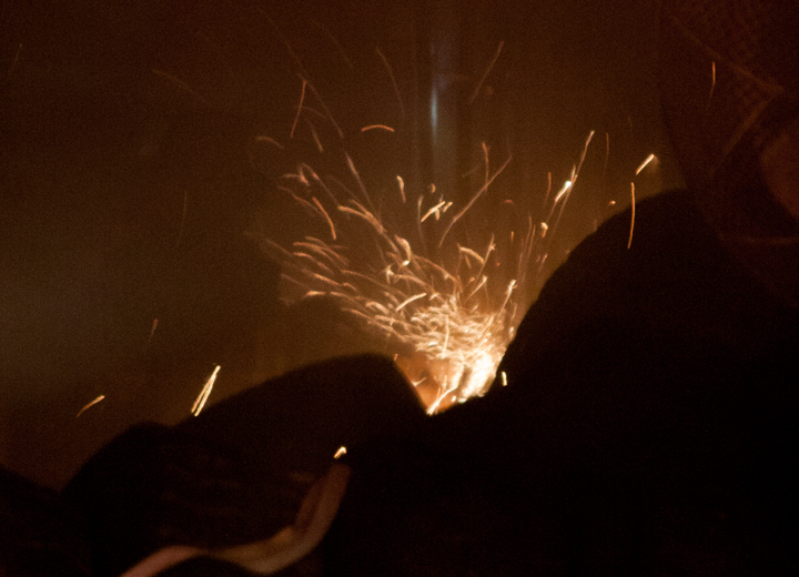 A fire fighter cuts their way through a wall.