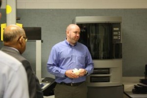 Penn State DuBois Assistant Professor of Materials Engineering Craig Stringer explains the functions of the 3-D printer to his left during the DCED tour of campus engineering facilities. (Provided photo) 