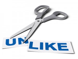 Scissors cut the word unlike in two parts, the first one with the suffix un and the second one with the word like, conceptual image for improving social relationship. (Provided image) 