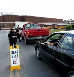 Lawrence Township Patrolman Julie Curry, front, prepares to deliver literature to a teen driver at the Clearfield Area High School. Curry was joined by Clearfield Borough Patrolman Nathan Curry, back, and they were two of many police officers at the school last week as part of a special Teen Seatbelt Mobilization. (Provided photo)