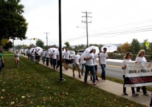 Men in high heels walk along Route 255 in front of campus during the Walk a Mile in Her Shoes event. (Provided photo)