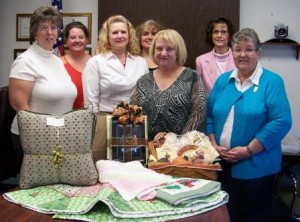 Some of this year’s committee members, (from left to right) Cathie Hugar, Valerie Darrow, Sheryl Bloom, Vicki Myers, Ellie Fenton, Ranea Brewer, and Alice Pollock, are showcasing just a few of the items up for bid at this year’s 18th annual Anne S. Thacik Charity Auction. (Provided photo)