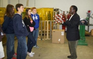 Professor of Engineering Daudi Waryoba explains the properties of powder metal samples to a group of high school students in one of the campus engineering labs. (Provided photo)