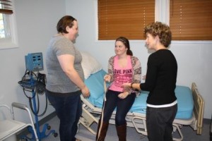 Sophomore OTA student Dakota Ott (seated) serves as a practice patient, while classmate Tammy Heckendorn practices a transfer exercise using the bed donated by KMA. OTA Program Director LuAnn Demi, at right, provides instruction. (Provided photo)