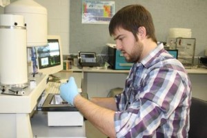 Nicholas Carrier examines samples of powder metal while running tests for his ongoing research project in a campus engineering lab. (Provided photo) 