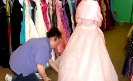 Pictured is Melissa Henry, Prom Closet coordinator, assisting a student with trying on a prom gown. (Provided photo)