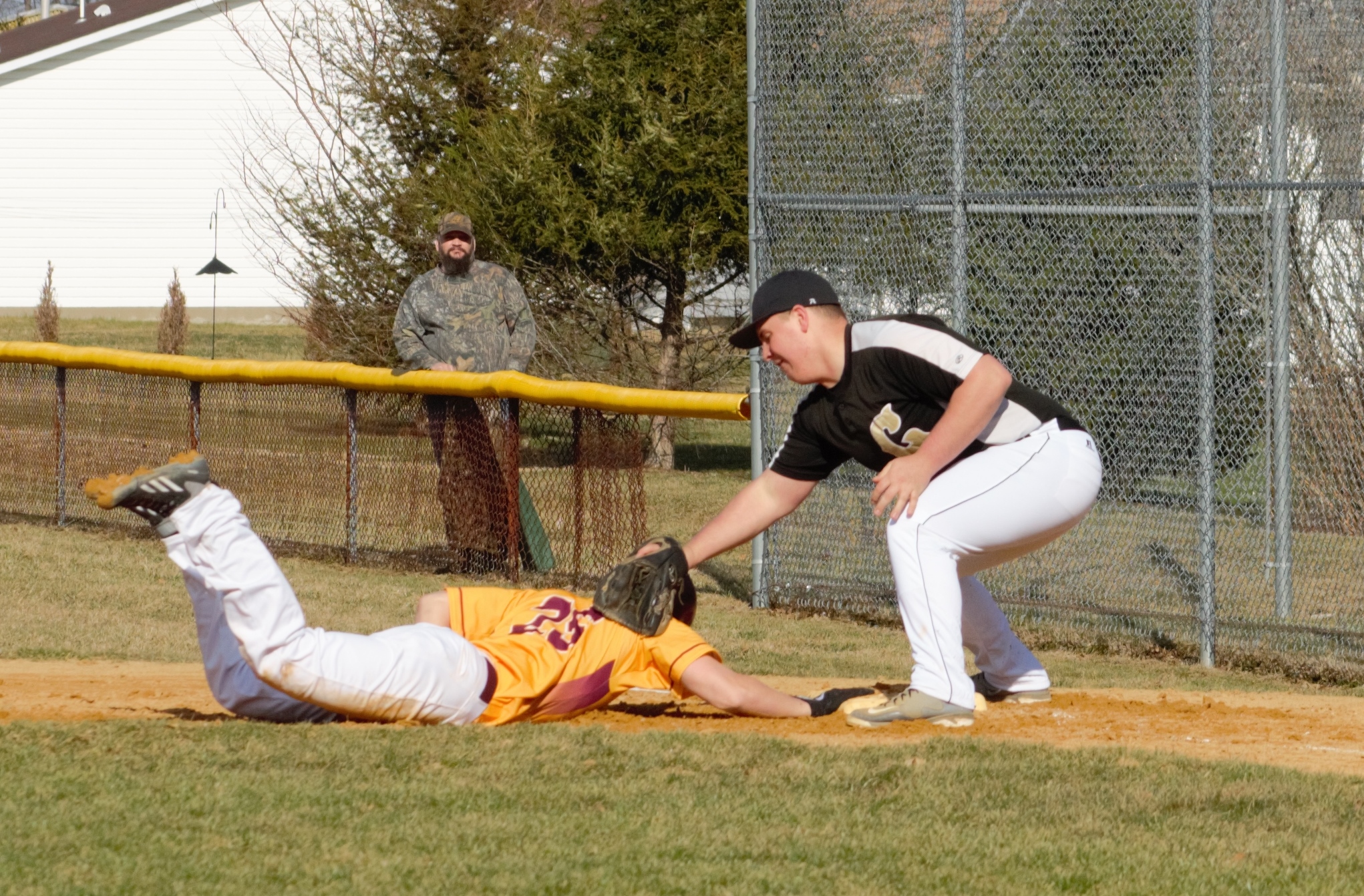 Golden Tide first-baseman Ricky Magnuson applies a late pick-off tag on ECC's Ivan Wortman in yesterday's game.  Wortman was 4-for-4 to help the Crusaders to a 3-1 win.