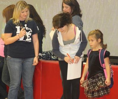 Left to right, Penn State DuBois OTA students Brittany Auman and Cassidy Lenox check Juniata Elementary School first grader Riley Mooney and her backpack for proper fit and weight.  Riley passed with flying colors. (Provided photo)