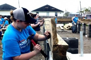 Student Jessica Metzger, in front, works with her classmates to construct the flooring system for a Habitat for Humanity Home in the Seventh Ward of New Orleans. The area was devastated by Hurricane Katrina in 2005 and, a decade later, the storm's impact on the landscape remains overwhelming. (Provided photo)