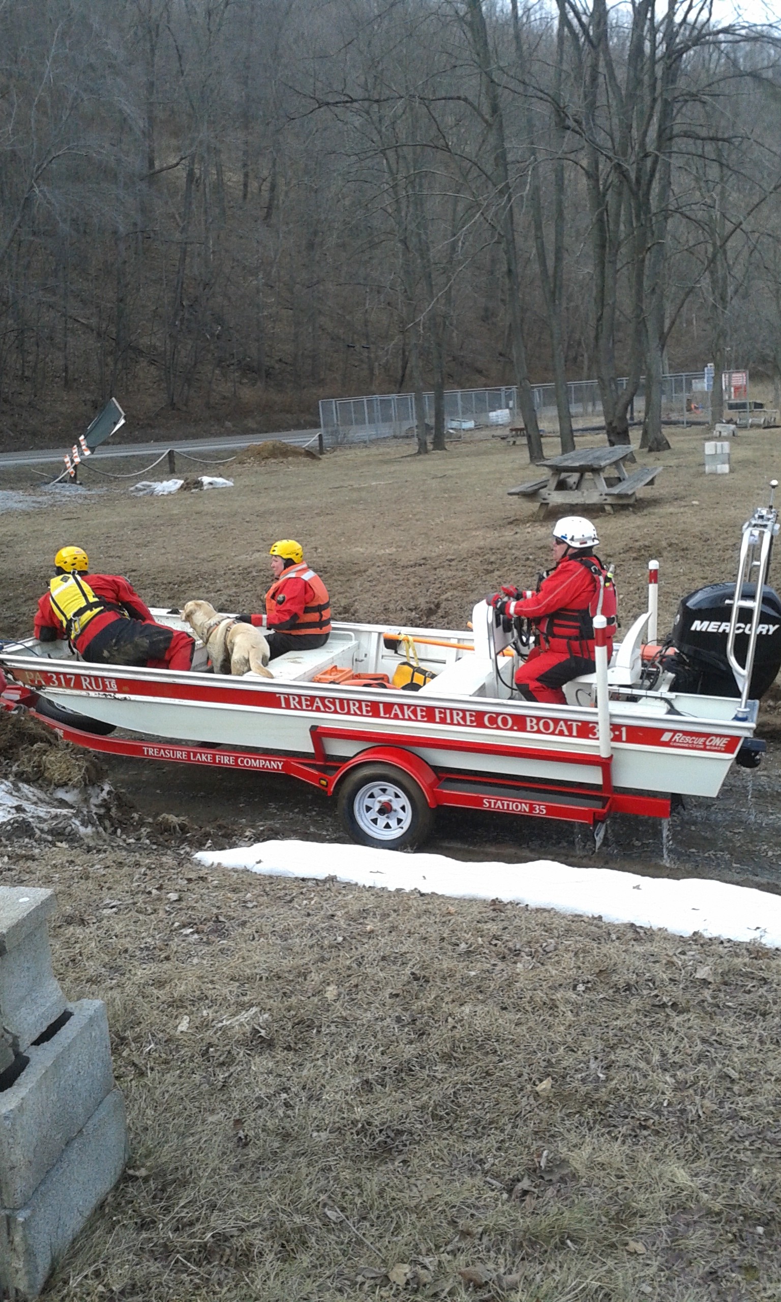 A dog team from Canine Aided Emergency Search and Rescue works together with the swift water rescue crew form Treasure Lake Volunteer Fire Department Sunday. Dog and boat crews spent several hours searching the river for 74-year-old James Coons. Coons left his home March 12 and has not returned.