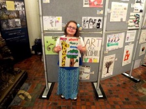 Isabella Walls shows off her winning poster from the Pennsylvania Liquor Control Board's contest.  Her poster was reproduced as a bookmark. (Provided photo)