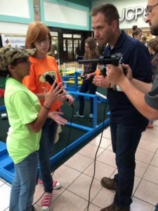 Local media students Ariel Forrest and Ashley Siple interview Steve Feldbauer of DuBois Penn State during a recent BEST Robotics Competition practice event at DuBois Mall, as Digital Media Instructor Sam Ettaro films.  (Picture by Jade Steele)