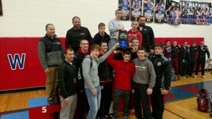 The Bison wrestlers and coaches hoist the team trophy