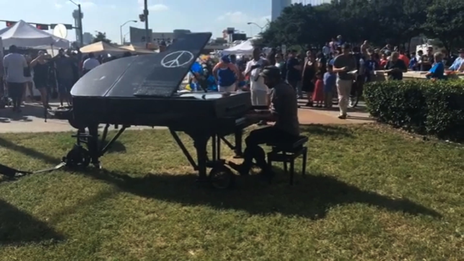 People gathered at a memorial outside the Dallas Police Department were taken by surprise on Sunday when a man pulled up on a bicycle, a piano in tow. Without saying a word, the gentleman began playing a rendition of John Lennon's "Imagine."