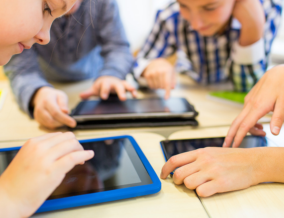 education, elementary school, learning, technology and people concept - close up of school kids with tablet pc computers having fun and playing on break in classroom