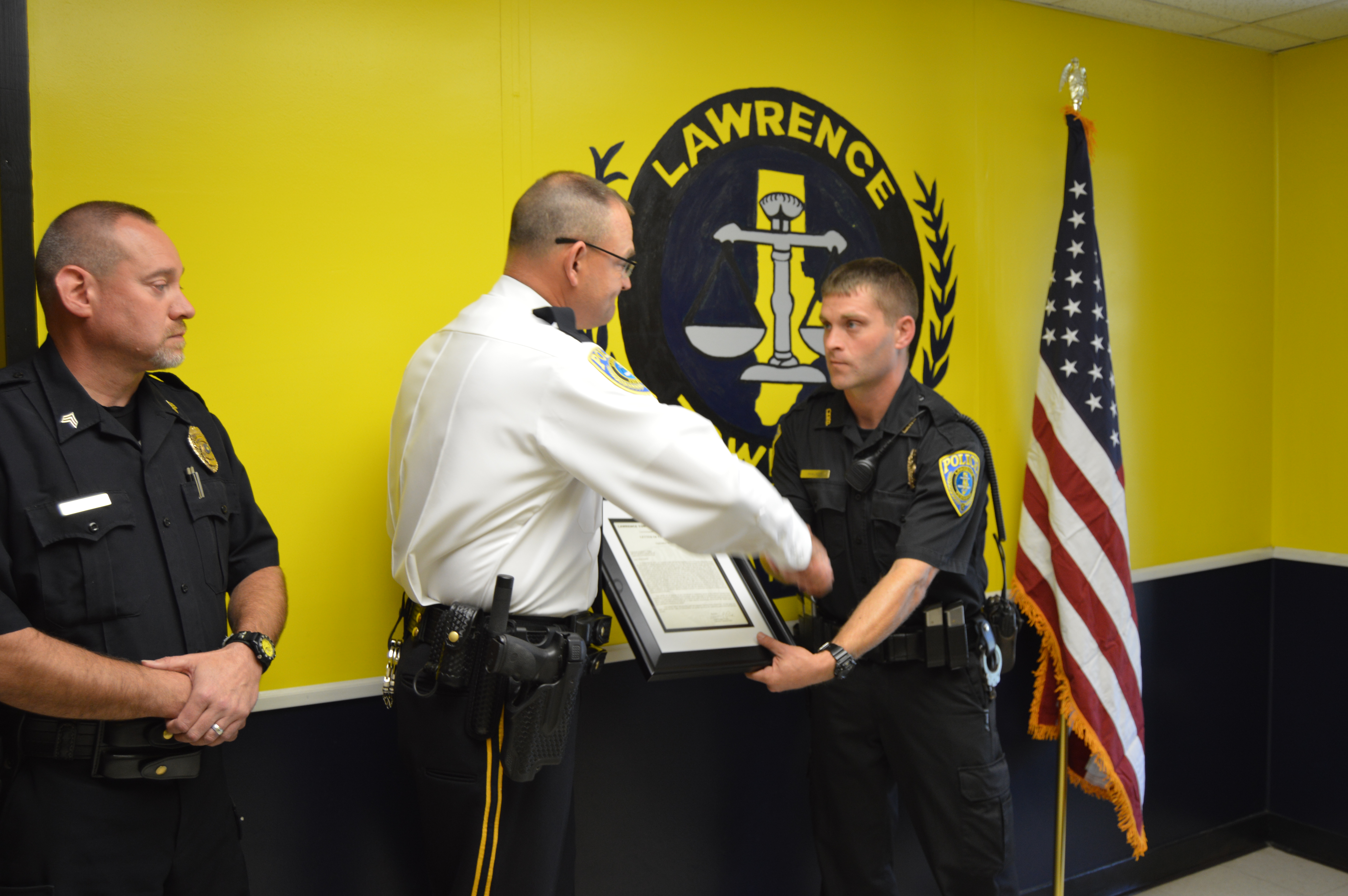Lawrence Township Police Chief Douglas Clark, center, and Sgt. Jim Glass, left, present a letter of commendation to Officer Jonathan Walker Wednesday at the police department. Walker, Clearfield Borough Police Sergeant Nathan Curry, and civilians Dakota Taylor and Damion Palmer were instrumental in rescuing 74-year-old Frances Lutz from a structure fire at Lawrence Park Village on Sept. 23. (Photo by Kimberly Finnigan)
