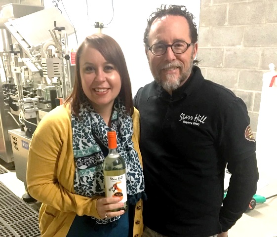 Marly Doty with Kenn Starr of Starr Hill Winery present a bottle of "Peeled". A portion of the sales of the new wine will support campus programs.  (Provided photo)