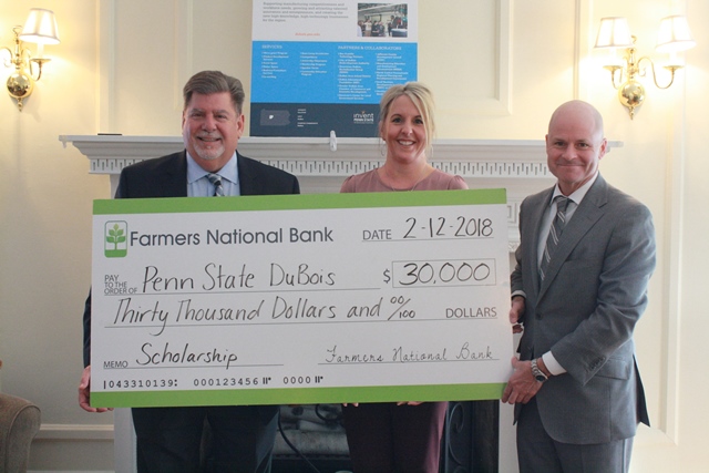 Penn State DuBois Chancellor M. Scott McBride, left, accepts a $30,000 check for the establishment of an Open Doors Scholarship from Farmers National Bank Vice President and Director of Retail Banking Danyell Bundy and President and Chief Executive Officer William C. Marsh.  (Provided photo)
