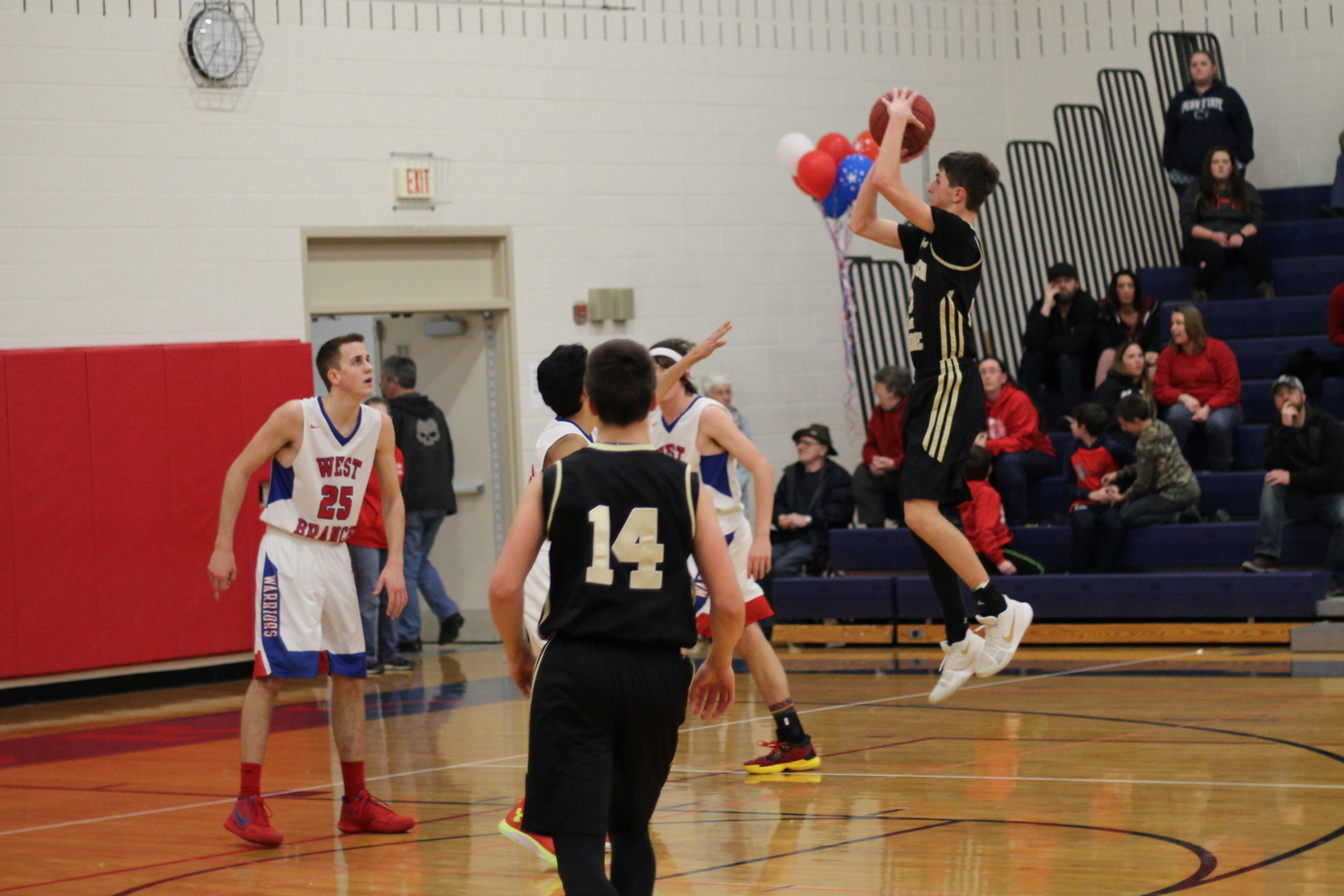 Josh Terry (in air) tries a pull back jump shot in the final quarter while Christian Bakaysa (14) and West Branch's Larry Cowder (25) look on.