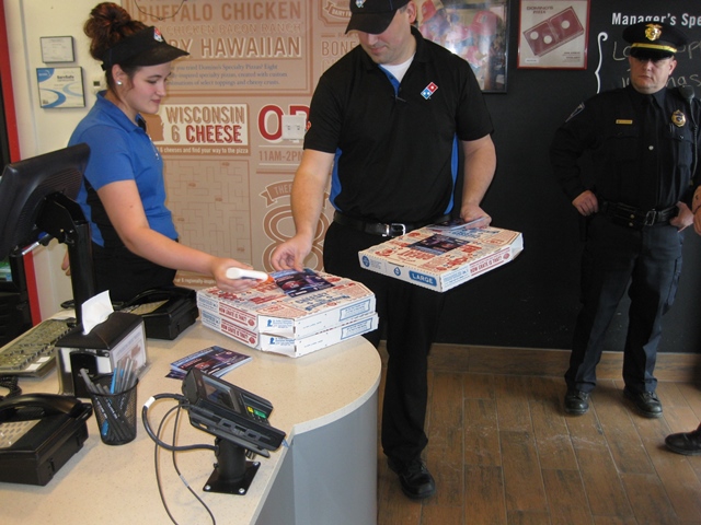 Domino's employees Kendra Beck and Greg Lightner are shown attaching the flyer to the pizza boxes. (Provided photo)