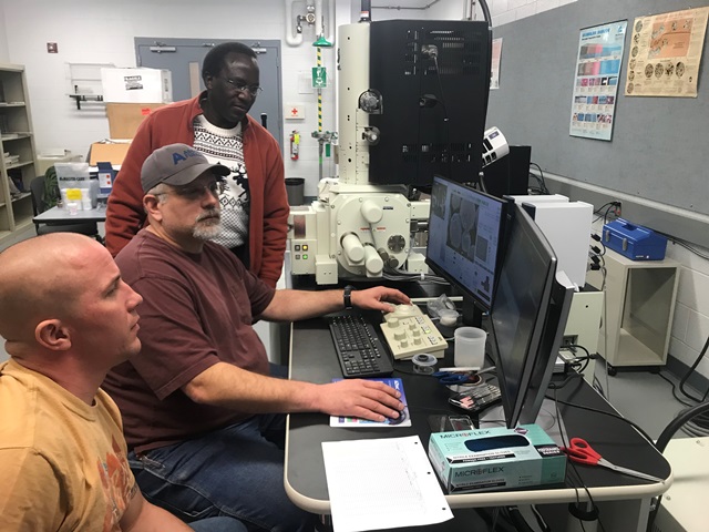 Front to back, student Cory Jamieson, Research Technician Glenn Rishel, and Assistant Professor of Engineering Daudi Waryoba examine the composition of powder metal samples under the new scanning electronic microscope. (Provided photo)