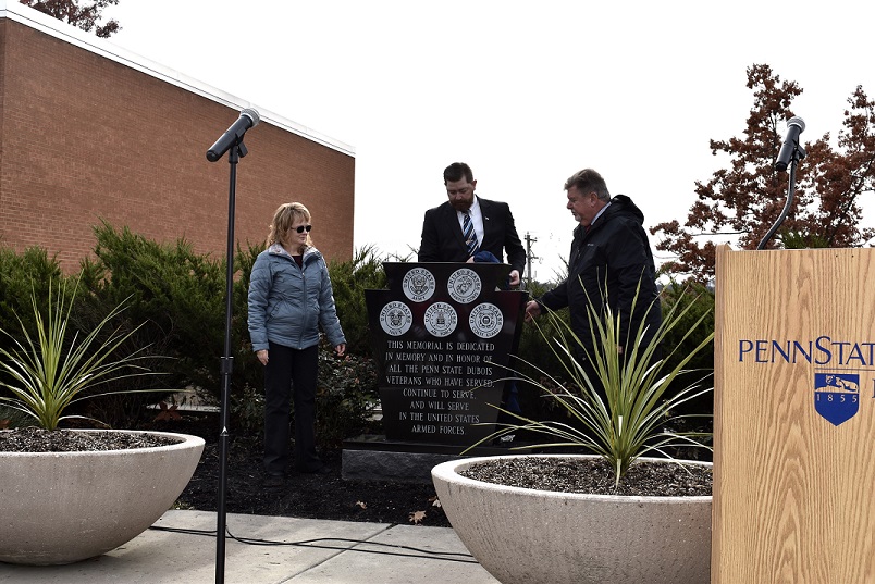 From left to right are Veterans Club Advisor Sueann Doran, Veterans Club President Ken Larsen and Chancellor M. Scott McBride, as they unveil the new Veterans Monument during ceremonies on Monday. (Provided photo)