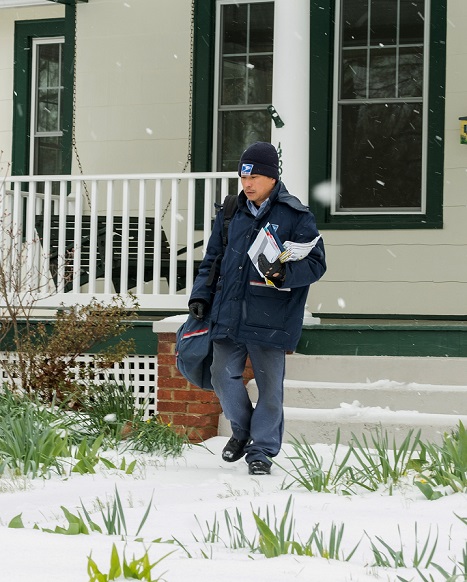Arlington Main Post Office letter carrier, Andy Lac, delivers mail during a late winter snow storm.