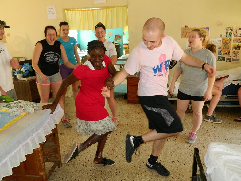 Lock Haven University senior, Dan McGonigal, dances with a patient during his second trip to Jamaica in 2018. (Provided photo)