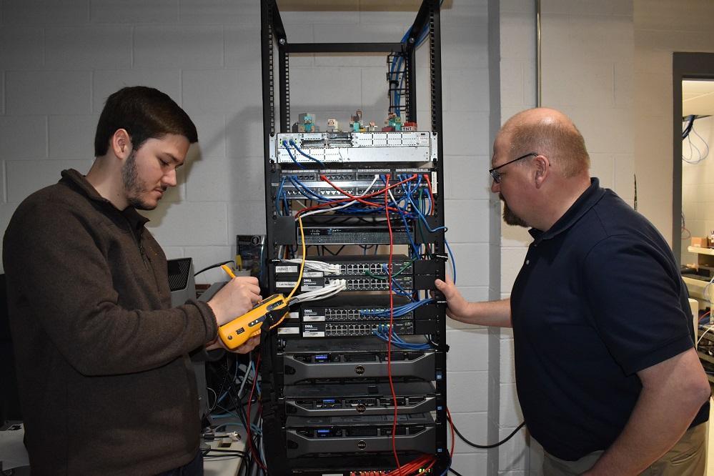 IST graduate CJ Seitz, left, and IST Program Leader Jason Long run tests on a server in the campus network lab. The lab network gives students the opportunity for hand-on, real-world learning in information technology.  (Provided photo)