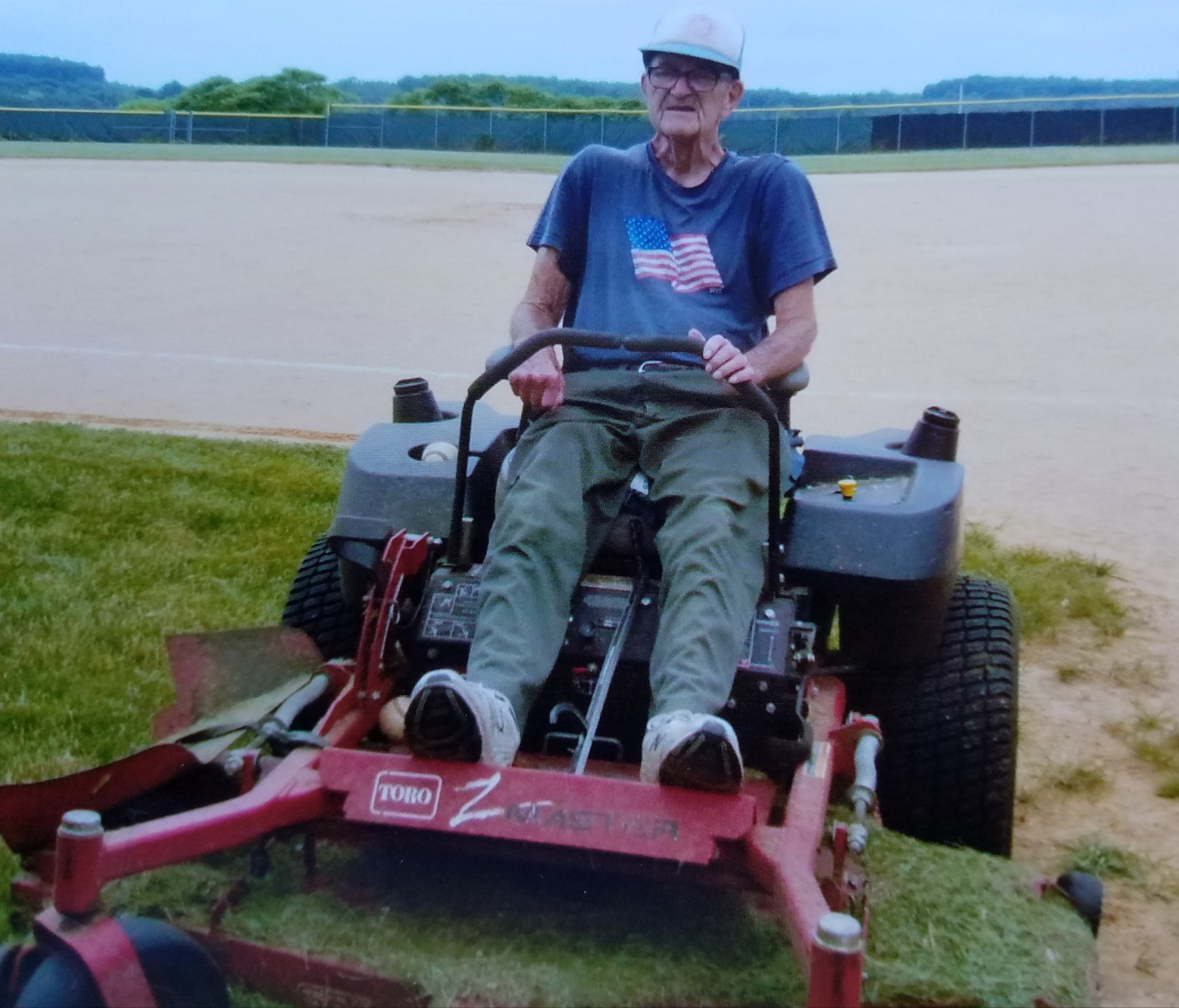 James A. Anderson sits astride his trusty Toro mower at the baseball field in the Lawrence Township Recreation Park. Anderson has volunteered to mow the fields and other grassy areas at the park for over 19 years. He said he started mowing after his retirement to help out a friend, but ended up taking over soon after. He said it takes him about seven hours, split between two days to mow the nearly 25 acres of grass at the park. (Photo by Kimberly Finnigan)