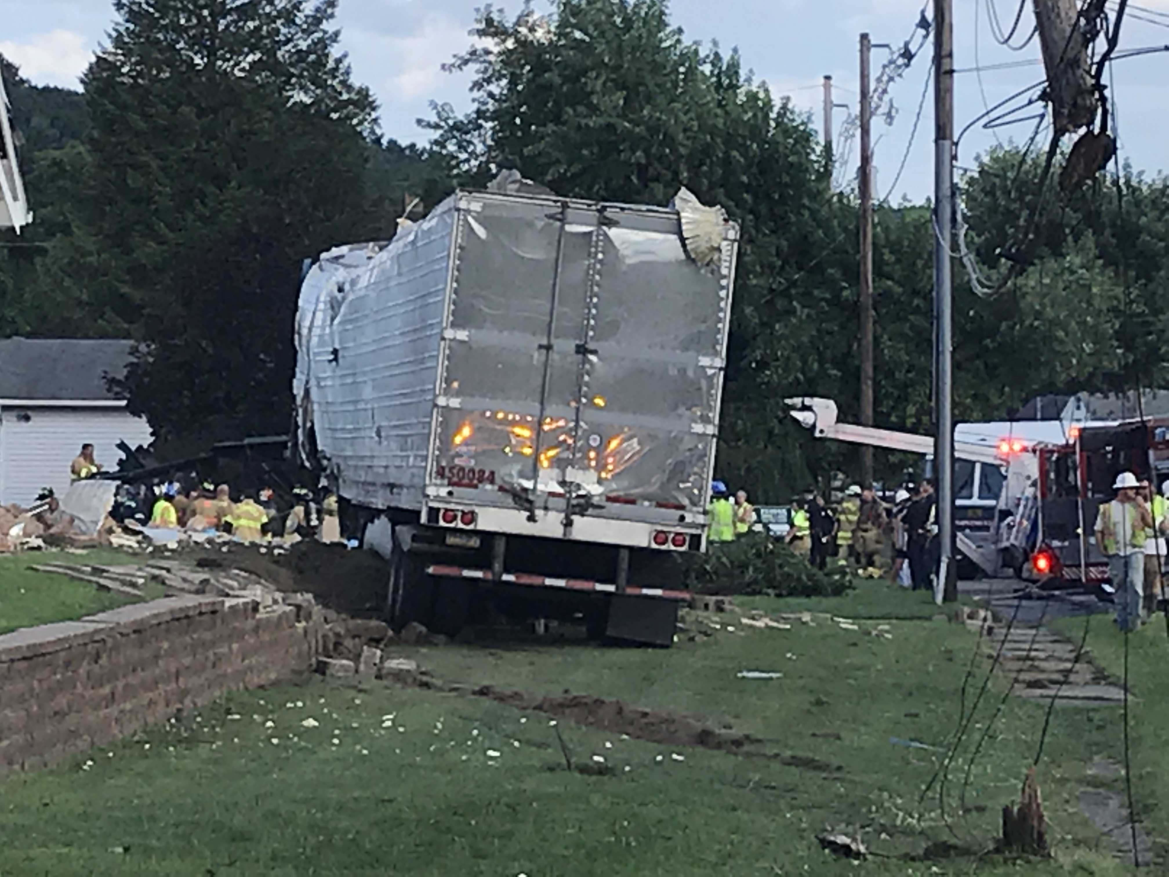Utility crews, firefighters, EMS and police work to free the driver of this tractor trailer. The vehicle struck the house, located at 201 Race Street and damaged several utility poles. The driver, whose name has not been released, was taken to Penn Highlands Clearfield, and later to a nearby trauma center. (Photo by Christene Dahlem)