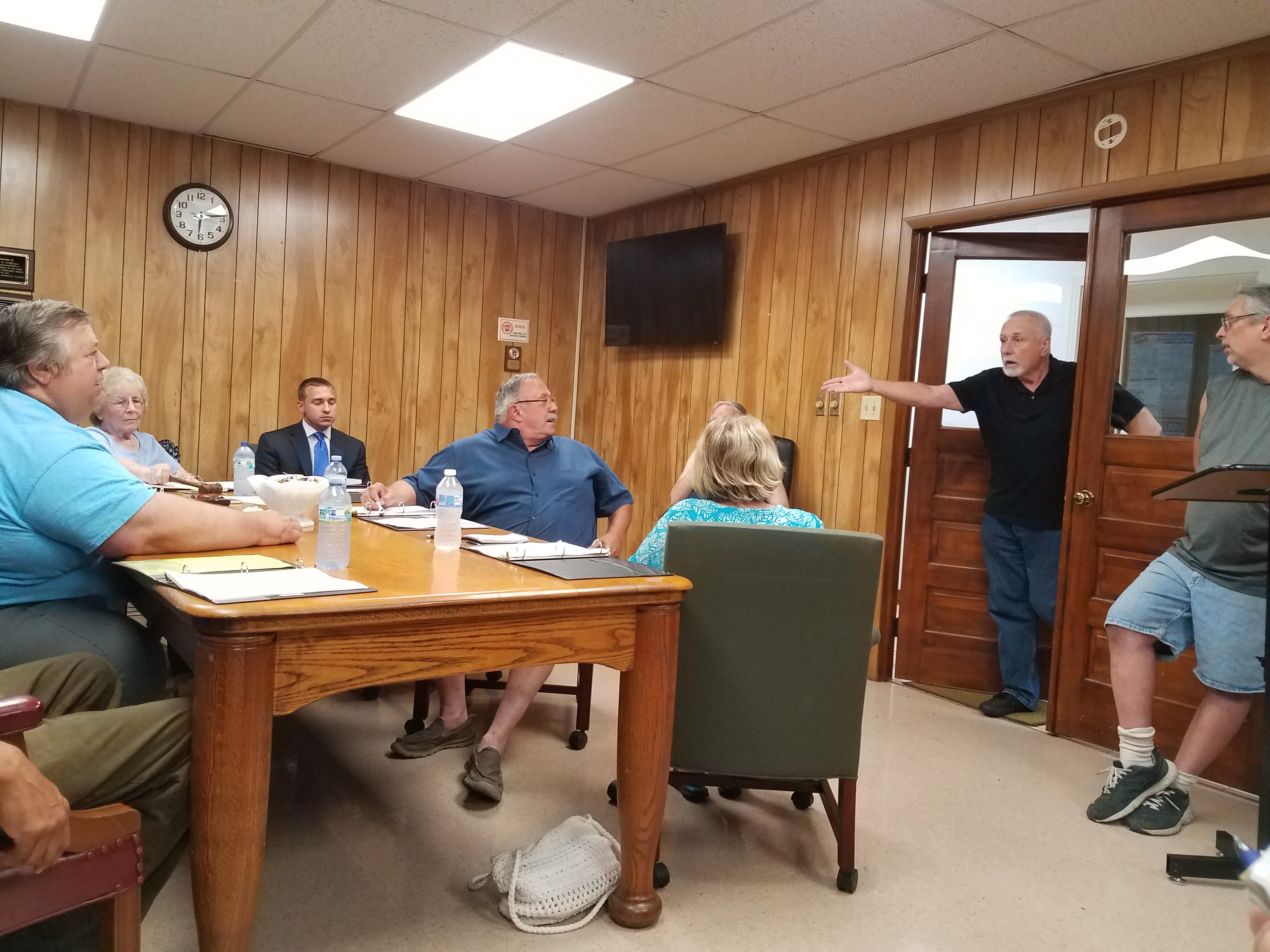 Tempers flared during Monday's Curwensville Borough Council Meeting. Major John Adams, (standing in doorway) declared that he was reinstating former Police Chief Mark Kelly. The council had voted 6-0 to terminate Kelly July 15. However, it is unclear whether Adams had the authority to reinstate the chief and the announcement lead to a heated exchange between Adams and Council Member Tom Carfley, left, seated. (Photo by Kimberly Finnigan)