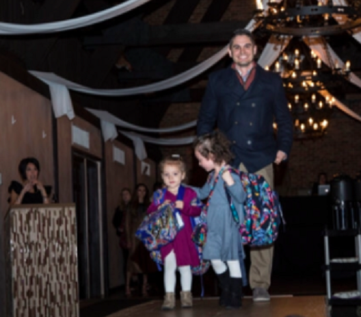 Dr. Chris Varacallo is accompanied by his daughters Leah and Cece as he walks the 2018 Free Clinic runway for Guzzo's & Co. (Provided photo)