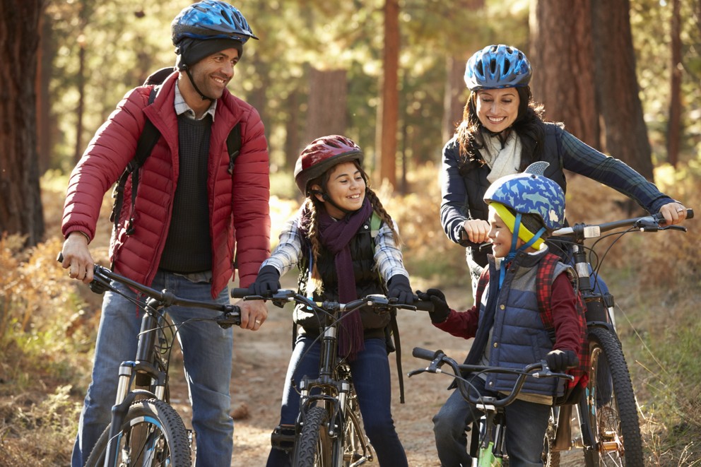 Hispanic family on bikes in a forest looking at each other