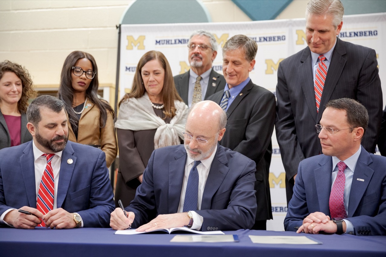 Governor Tom Wolf, center, State Rep. Mark Rozzi, a survivor of childhood sexual abuse, left, and Attorney General Josh Shapiro, sign a package of three bills, which mirror three of the Grand Jury’s recommendations on addressing the statute of limitations for victims of child sexual abuse, inside Muhlenberg High School on Tuesday, November 26, 2019.