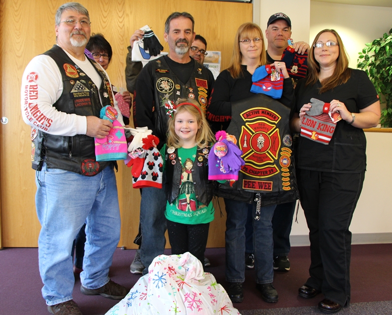 Pictured are representatives of the Red Knights International Motorcycle Club, Altoona PA Chapter 39 making a donation of children’s winter hats and gloves at the Tyrone Rural Health Center.  Pictured, from left to right in the front row, are: Ryleigh Dillon and Junior Member.  In the middle row are Greg Givler, Quartermaster, Emmett Duprey Chapter president, Joyce Duprey, secretary, and Shonda Moon, NRCMA, outpatient coordinator, Tyrone Regional Health Network. In the back row are: Donna Givler, Jack Wilkes and Harry Dillon, road captain. (Provided photo)