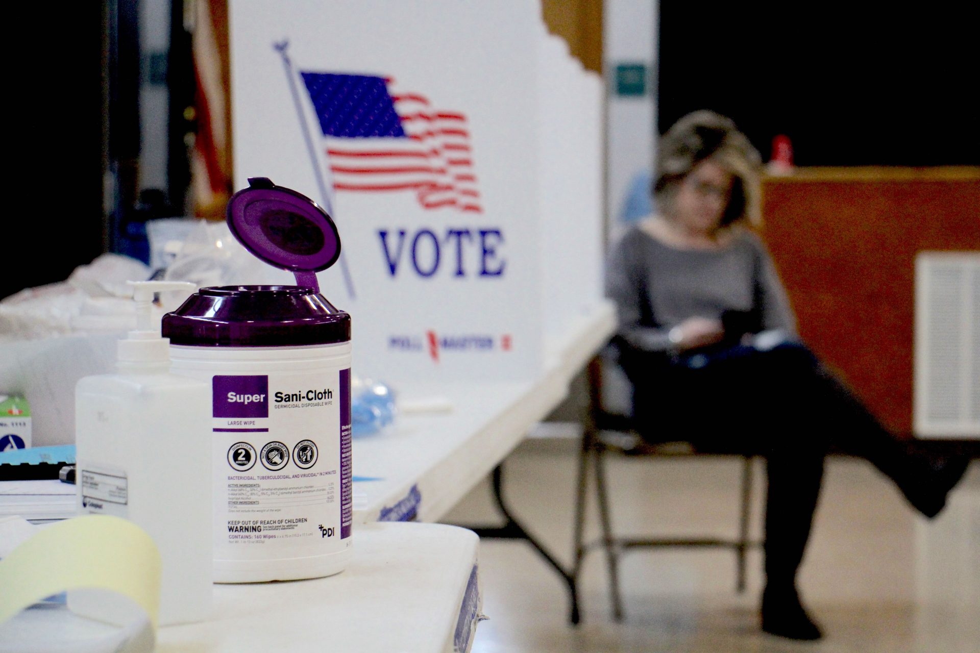 Poll worker Dina Sebold waits for voters at Cecelia Snyder Middle School in Bensalem during a special election for a vacant seat in the Pennsylvania House of Representatives. Hand sanitizer and wipes were made available to voters, many of whom brought their own pens. (Emma Lee / WHYY)