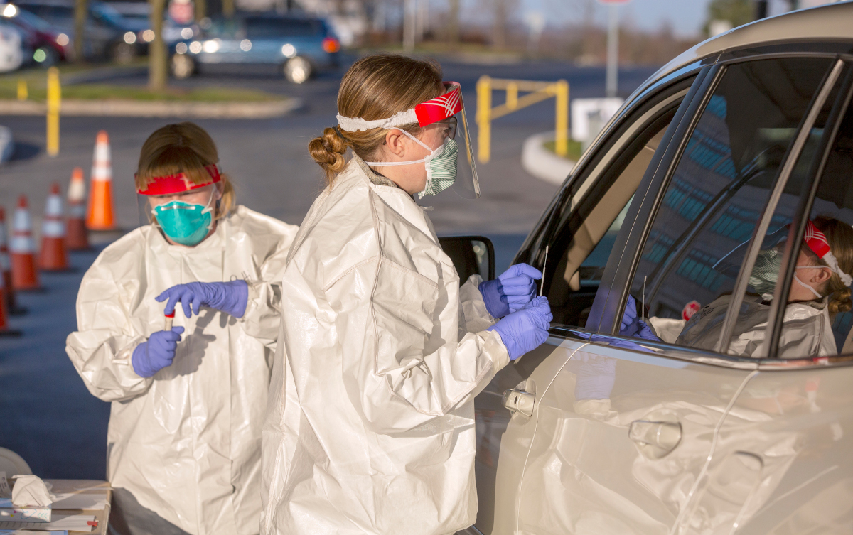 Heather Secord, a licensed practical nurse for Penn State Health, explains to a patient in their car how she will be using a swab to test for the COVID-19 virus at the drive through area on Wednesday, March 18, 2020.  This service on the Penn State Heath Milton S. Hershey Medical Center campus, is only for patients who have been virtually pre-screened through the COVID-19 screening module of the Penn State Health On Demand app.