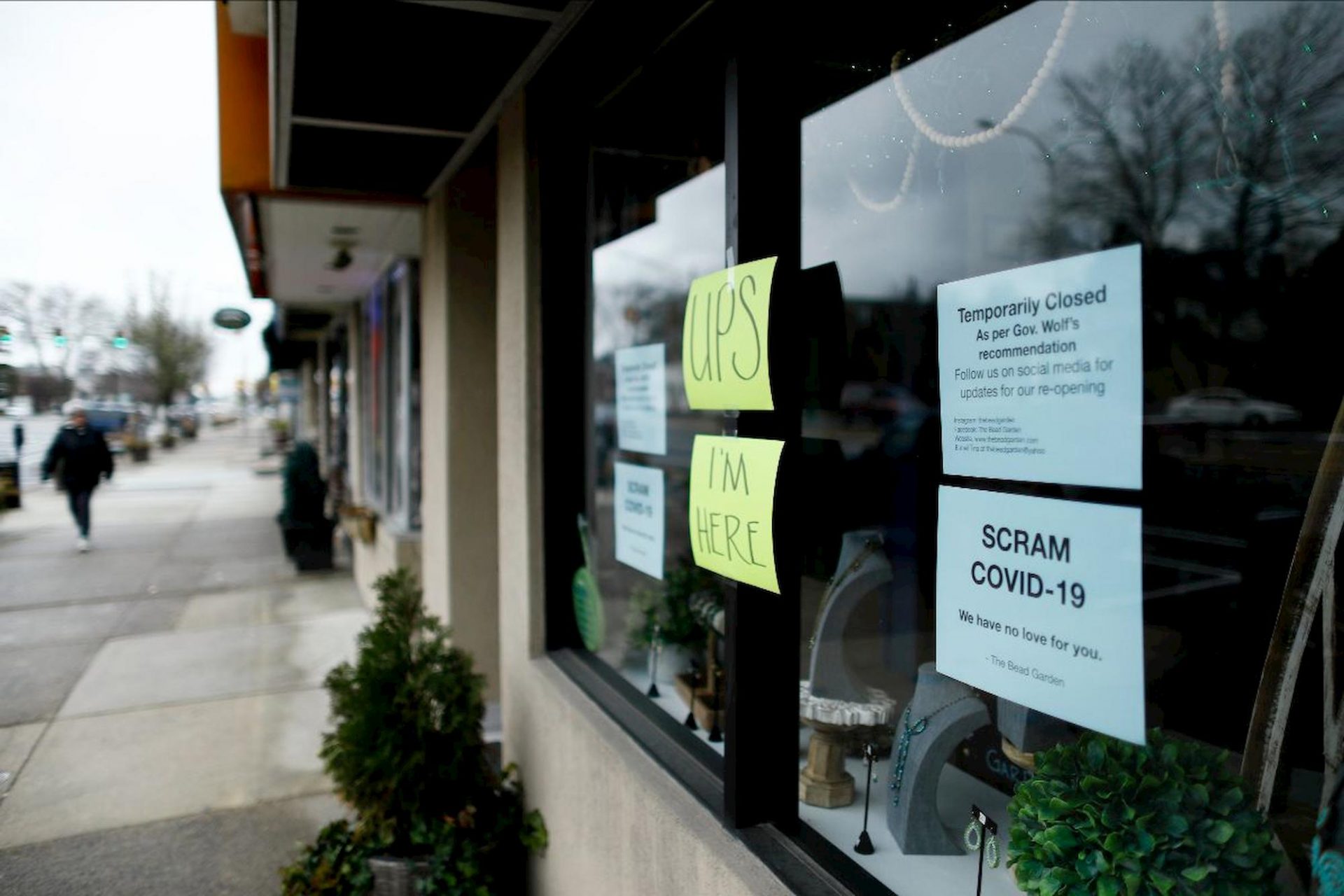 A person walks past a closed craft store, Tuesday, March 17, 2020, in Havertown, Pa. Concerns about the new coronavirus have led to the temporary closure of many businesses and schools across the region. (AP Photo/Matt Slocum)