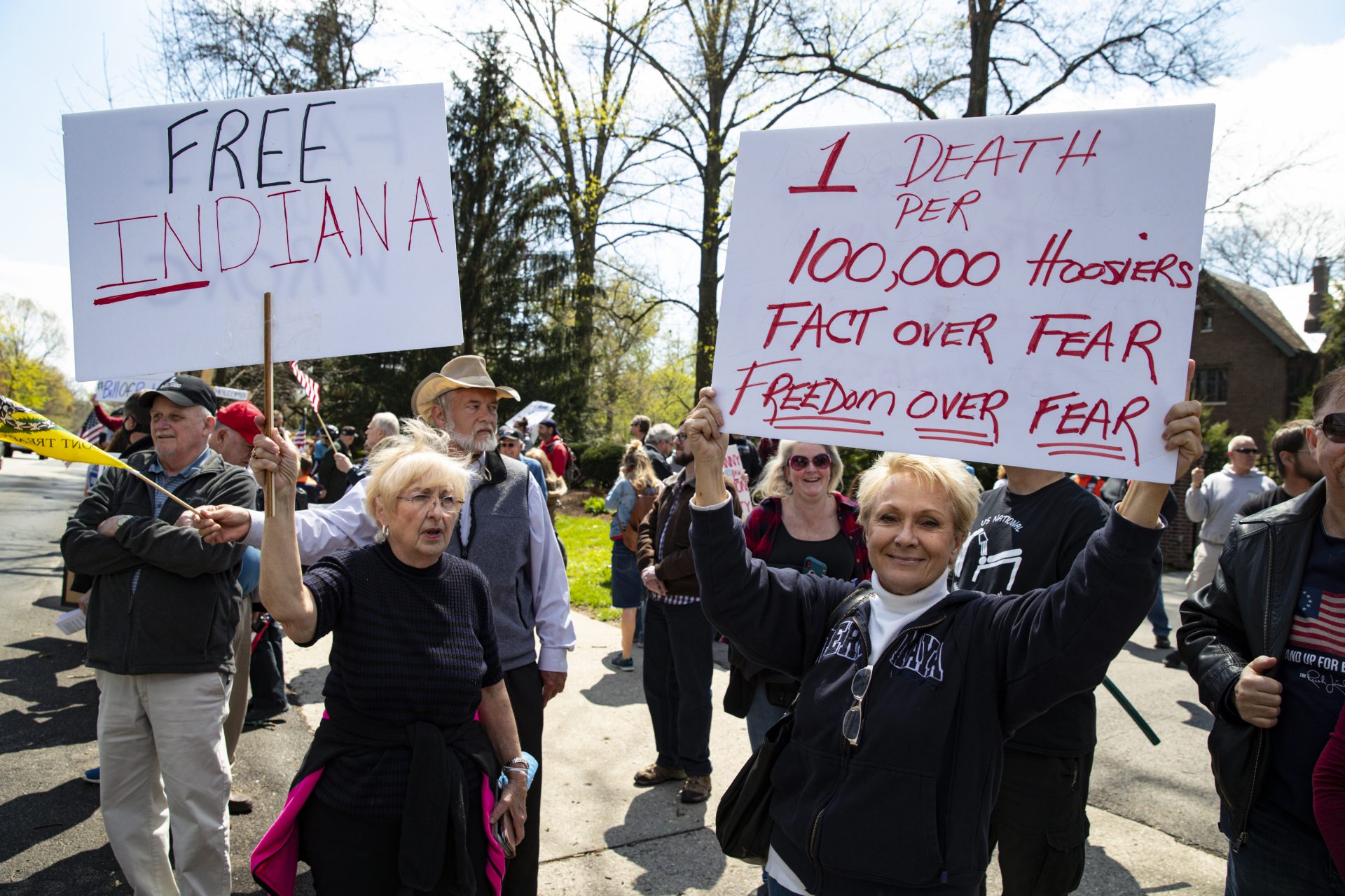 Protesters gather outside the Indiana Governor’s mansion in Indianapolis, Saturday, April 18, 2020, urging Gov. Eric Holcomb to back off restrictions on Indiana residents because of the coronavirus, and restart the economy. (AP Photo/Michael Conroy)