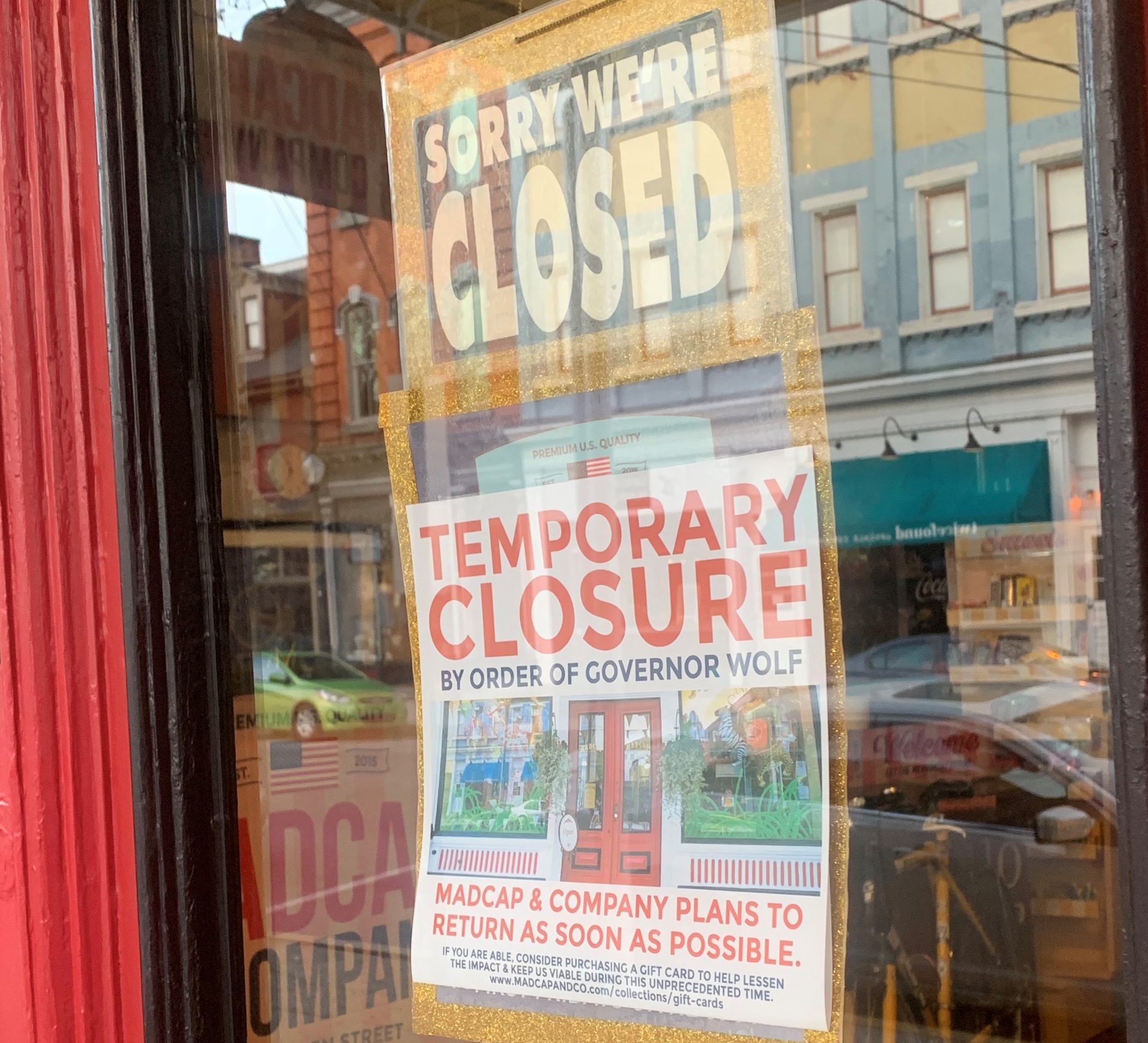 A sign hangs in the door of Madcap & Company, a novelty store in Lancaster, Pa. (Russ Walker / PA Post)