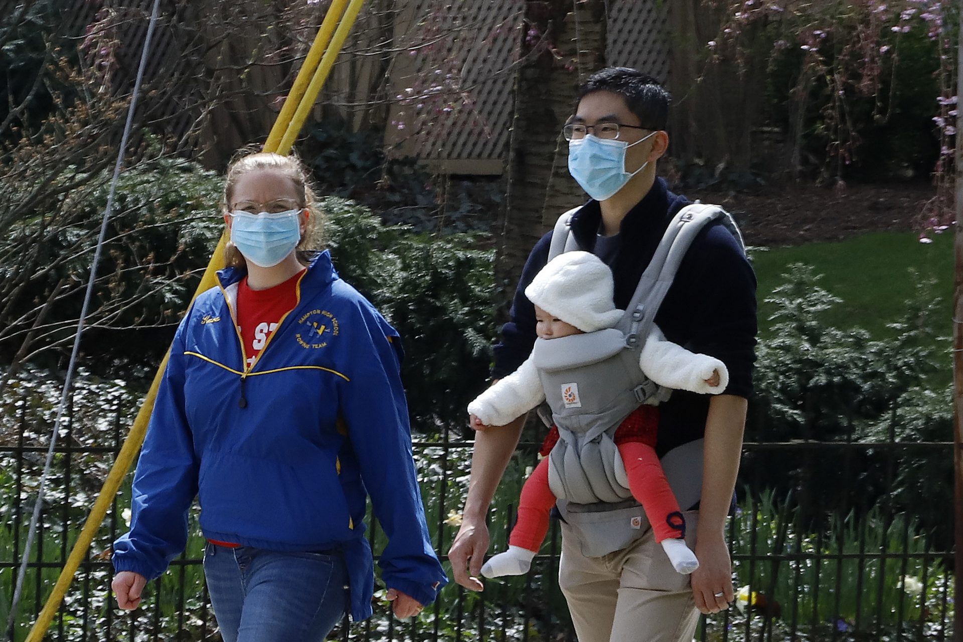 A couple out for walk wear protective masks on a warm afternoon in Pittsburgh, Sunday, April 5, 2020. (Gene J. Puskar / AP Photo)