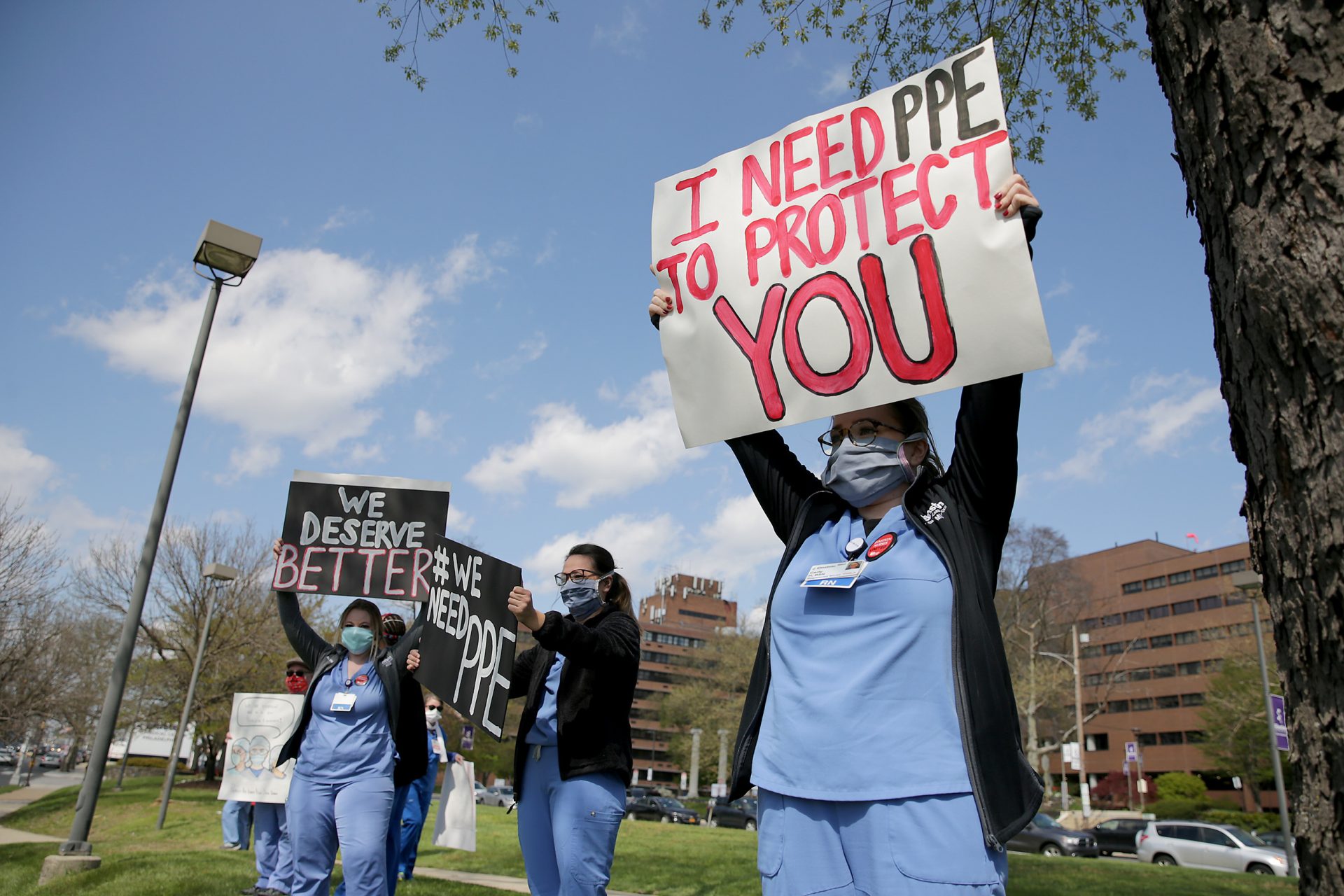 Carly Heller, an ICU nurse at Einstein, at right, holds up a sign with her coworkers outside Einstein Medical Center in Philadelphia, PA on April 15, 2020. Nurses and healthcare professionals gathered outside area hospitals on Wednesday to demand PPE and safe patient care standards as they battle the coronavirus. Heller said they have to wear the same mask for 20 shifts before they are given a new one.

 DAVID MAIALETTI / Philadelphia Inquirer