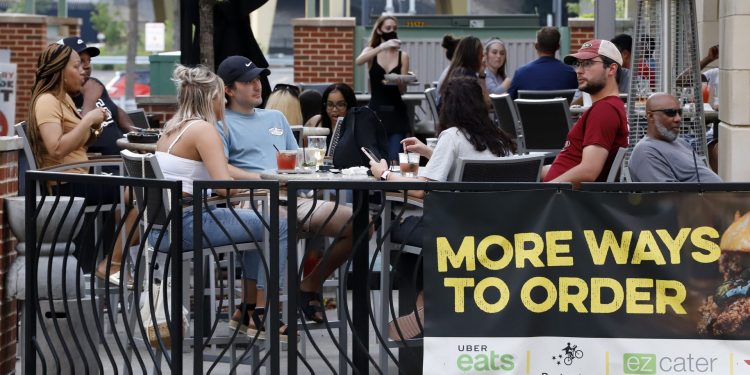 People gather at tables outside Bar Louie on the Northside of Pittsburgh Sunday, June 28, 2020. In response to the recent spike in COVID-19 cases in Allegheny County, health officials are ordering all bars and restaurants in the county to stop the sale of alcohol for on-site consumption beginning on June 30. (Gene J. Puskar / AP Photo)