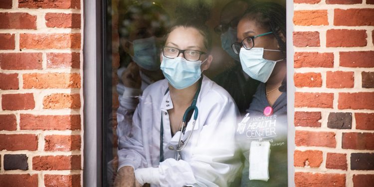 Lancaster Health Center employees watching through a window on Friday, July 24, 2020, as Gov. Tom Wolf visited to speak about the need to ensure the community’s most vulnerable receive care during COVID-19 and year-round. (Image via Gov. Wolf’s Flickr page)