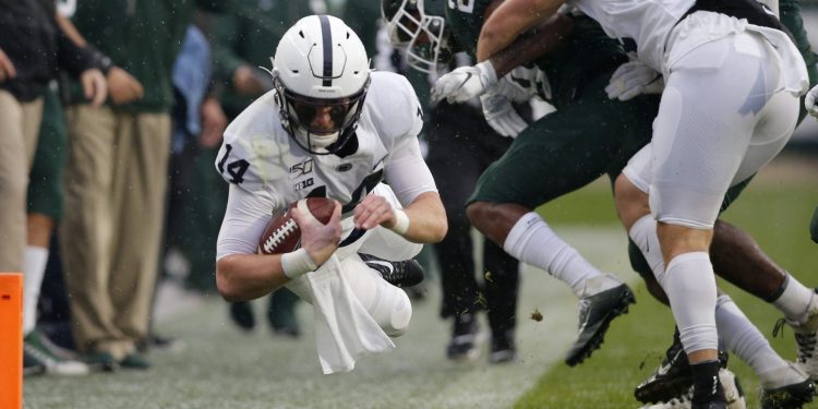 Penn State quarterback Sean Clifford, left, dives for a first down against Michigan State’s Shakur Brown (29) during the first quarter of an NCAA college football game, Saturday, Oct. 26, 2019, in East Lansing, Mich. (AP Photo/Al Goldis)