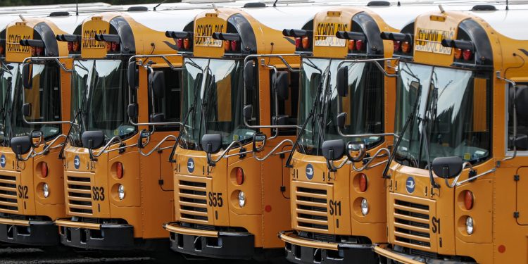 Rows of school buses are parked at their terminal, Friday, July 10, 2020, in Zelienople, Pa. (AP Photo/Keith Srakocic)