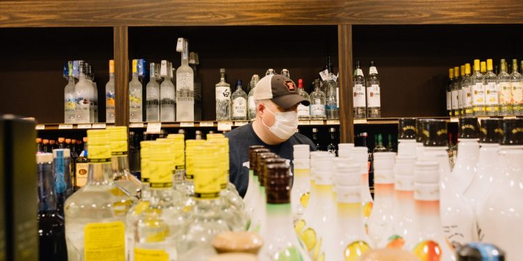 A customer wears a mask while shopping at a Fine Wine and Good Spirits store in Cumberland County on May 22, 2020, the first day the store reopened to shoppers after having been closed due to the coroanvirus.  Kate Landis / PA Post